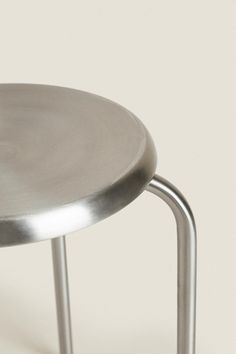 a round metal table sitting on top of a white floor