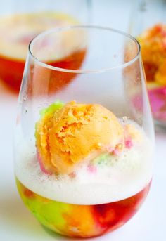 an ice cream sundae in a wine glass on a table with other desserts