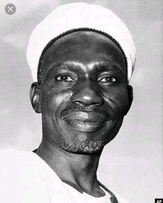 a black and white photo of a man in a sailor's cap smiling at the camera