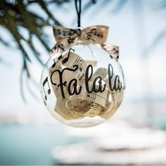 a glass ornament hanging from a tree with musical notes on it's side