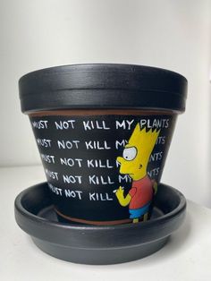 a potted plant sitting on top of a white table next to a black plate