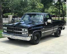 a black pickup truck parked in front of a house