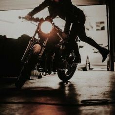 a man riding on the back of a motorcycle in front of a garage door at night