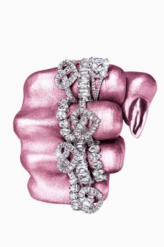 a pink ring with diamonds on it's side and in the middle of its hand