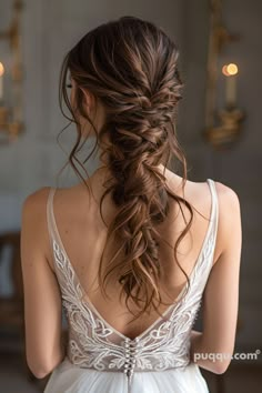 the back of a woman's head with long hair in a low ponytail, wearing a wedding dress