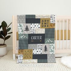 a baby crib with a blanket that says, adventure is here and there are trees on it