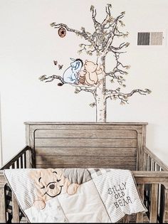 a baby crib with winnie the pooh wall decal