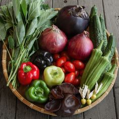 a basket filled with lots of different types of veggies on top of a wooden table