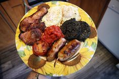 a yellow plate topped with different types of food on top of a wooden table next to a stove