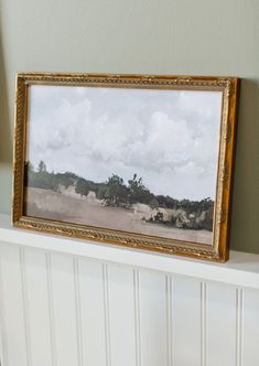 a painting hanging on the wall above a radiator in a room with white paneling