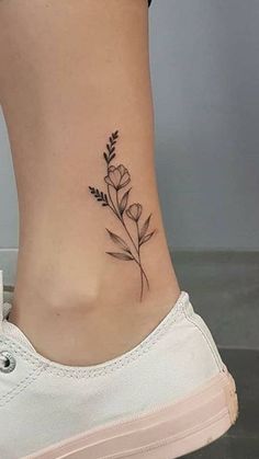 a woman's foot with a small flower tattoo on the side of her leg