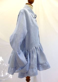 Cool Repurposed Peplum with Button Down Collar & Flounces made from 2 Vintage Linen Men's Shirts. Using only pristine vintage clothing, I mix up the mix, interchanging parts from several garments to reconstruct  a new spin on a fresh design.  The finished shirt is made from two different linen shirts (one Baby Blue & White stripes the other Baby Blue and White mini checks)  from my husbands hand me downs. I have re stitched the Sleeves and cuffs to suit a women's body. This Shirt is Loose, Cool and Breezy for those hot Summer days.   Buttoned cuffs and Button Down Collar. Buttons closure. Sizes - Fits Small Medium and Large. Material and Care:  Material information: 100% Linen 40oC coloured wash Do Not Bleach Do Not Tumble Dry Iron Medium Heat Each shirt is a one of a kind.  All garments a Mens Shirt Upcycle Woman, Woman Shirt Design, Long Sleeve Ruffled Shirt With Relaxed Fit, Relaxed Fit Long Sleeve Shirt With Ruffles, Long Sleeve Cotton Tops With Covered Buttons, Cotton Long Sleeve Tops With Covered Buttons, Button Up Shirt Upcycle, Reworked Button Down, Women Shirt Designs