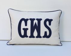 a white and blue pillow with the word gns on it's front side