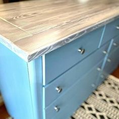 a blue dresser sitting on top of a wooden floor