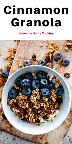 a bowl filled with granola on top of a cutting board next to blueberries