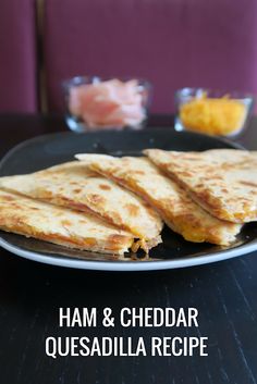 ham and cheddar quesadilla recipe on a black plate with the words ham and cheddar quesadilla