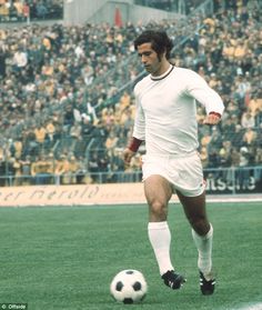 a soccer player is running with the ball in front of an empty stadium full of people