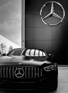 a mercedes car is parked in front of a building with a mercedes logo on it