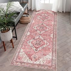 a large red rug with an ornate design on the floor in front of a window