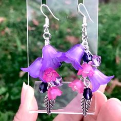 Gorgeous lucite earrings  these are gorgeous and festive , I used various bell flower charms and light fuchsia tulip shaped charms with pearls inside , silver toned and I also used purple crystals , unique .  Ear wires are nickel free Bohemian Style Resin Flower Earrings As Gift, Bohemian Resin Earrings With Ear Wire, Bohemian Resin Earrings As Gift, Purple Drop Chandelier Earrings As Gift, Unique Flower-shaped Resin Earrings, Unique Purple Earrings With Ear Wire, Resin Dangle Flower Earrings With Ear Wire, Handmade Purple Flower Earrings Whimsical Style, Dangle Flower Earrings With Resin And Ear Wire