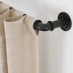 the curtain rod is attached to the side of a window with two black handles on it