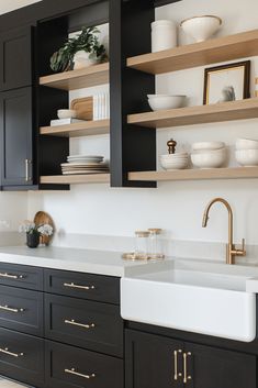 a kitchen with black cabinets and white counter tops