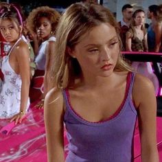 a group of young women standing next to each other on top of a pink carpet