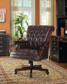 a brown office chair sitting on top of a rug in front of a computer desk