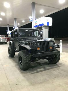 a black jeep parked in front of a gas station