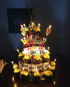 a birthday cake with cupcakes and lit candles