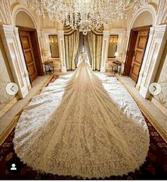 the bride's wedding dress is on display in an elaborately decorated room with chandeliers