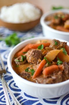 two bowls filled with stew and vegetables on top of a blue and white table cloth