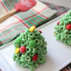 two christmas trees made out of cereal krispy kreme treats on a white plate