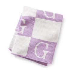 a purple and white checkered towel with the letter g on it