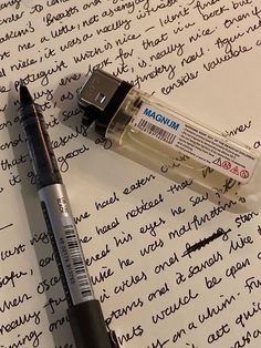 the pen is laying on top of an old paper with writing and a usb drive