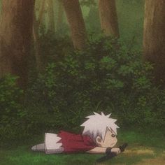 an anime character laying on the ground in front of some trees and bushes with his head down