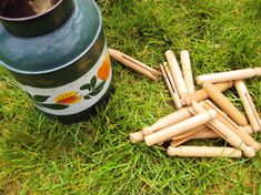 a bunch of wooden sticks laying on the ground next to a pot and some grass