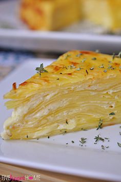 a close up of a piece of food on a plate with some herbs around it