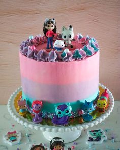 there is a cake decorated with cartoon characters on the top and bottom layer, along with other decorations