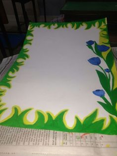 a sheet of paper with blue flowers painted on it sitting on top of a table