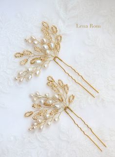 two gold hair pins with pearls and leaves on white fabric background, one is for the bride