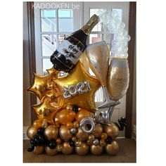 an assortment of champagne and balloons in front of a window