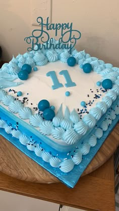 a blue and white birthday cake with the number 11 on it