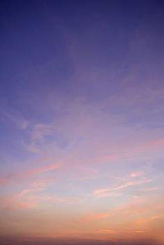 two people standing on the beach at sunset