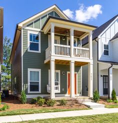 a two story house with white trim and green siding