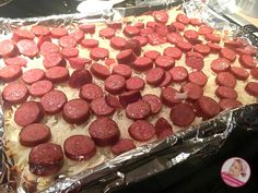 a pan filled with cooked sausages on top of tin foil