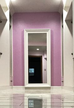 an empty bathroom with pink walls and white tile on the floor is seen in this image