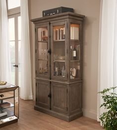 a wooden cabinet with glass doors in a living room