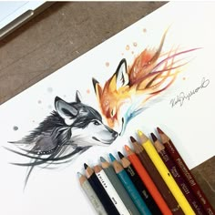 some colored pencils are sitting next to a drawing of two foxes and one fox