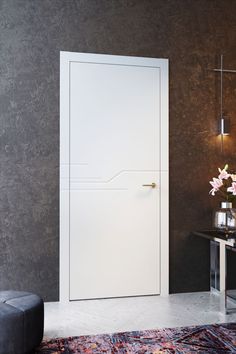 a white door in a room next to a table with flowers and vases on it